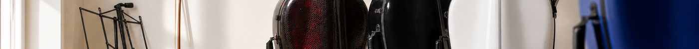KI-generiertes Titelbild: verschiedene Cellokästen in Carbon, Schwarz, Weiß und Blau im hellen Musikzimmer; keine reale Produktszene.